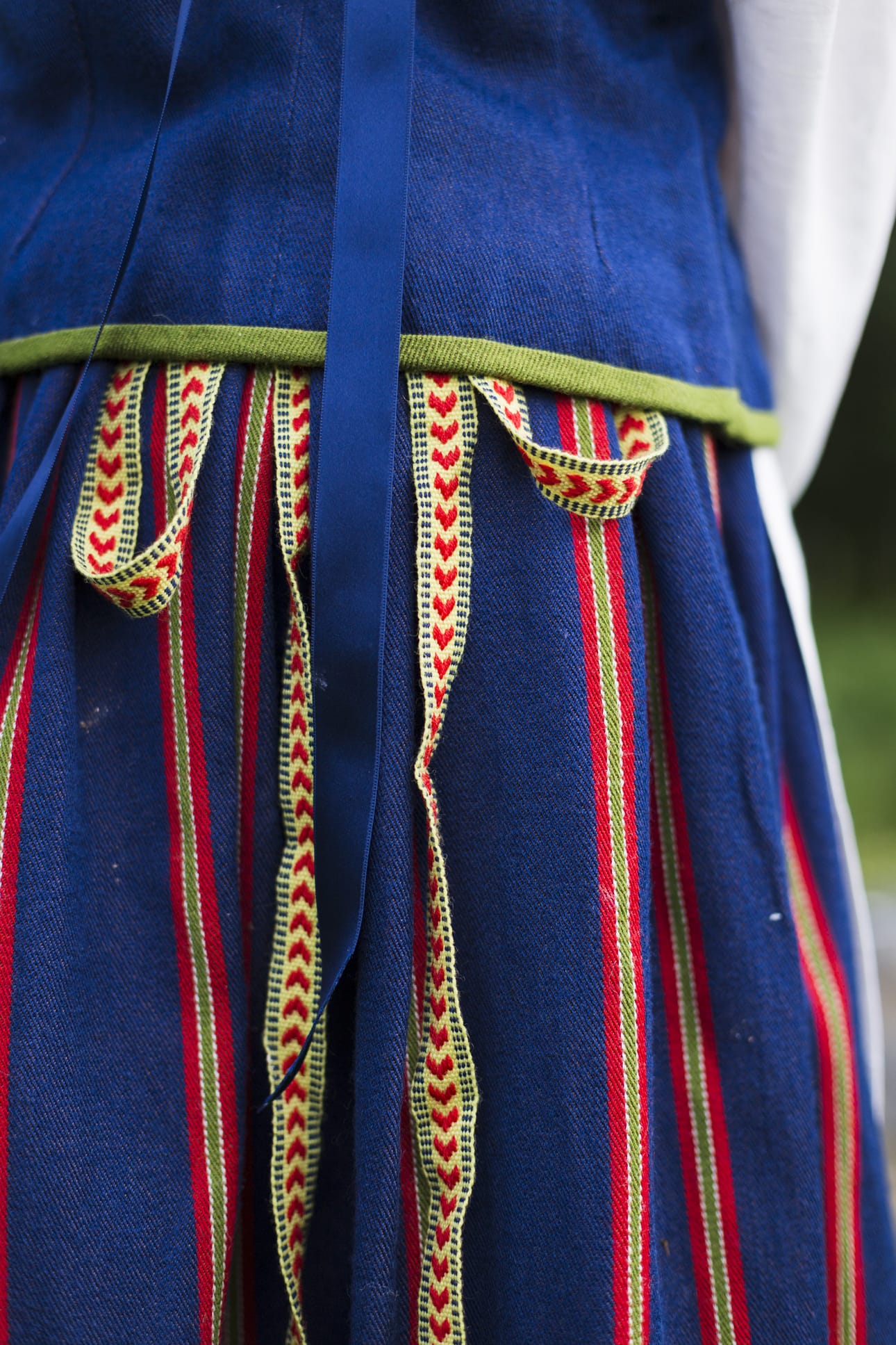 Koillismaan kansallispuvussa hehkuvat punainen, keltainen ja vihreä syvää sinistä vasten. Pirtanauhan kuviota kutsutaan lohenpyrstökuvioksi.