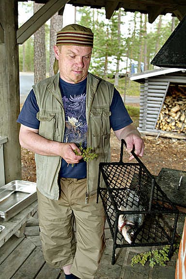 Rauno Säkkinen käyttää kalan savustuksessa lepänpurujen ohella myös tuoreita katajan oksia.