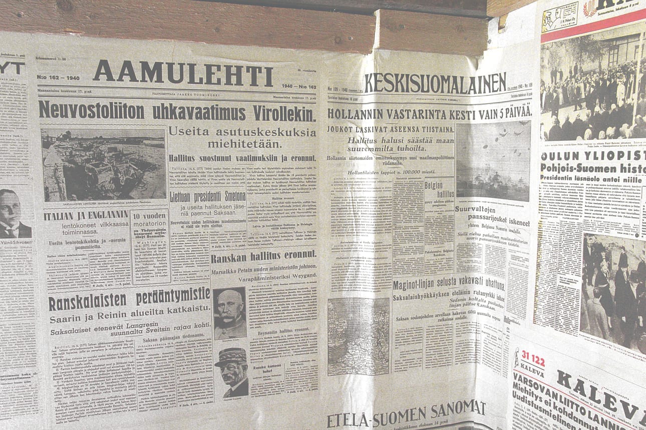 Vanhanajan sanomalehtitapettia seinällä.