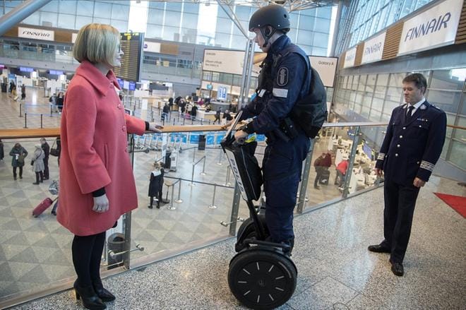 Helsinki-Vantaan lentokentällä työskentelevät poliisit kantavat jatkossa työtehtävissä mukanaan konepistoolia repussa. Vanhempi konstaapeli Mika Korpela (keskellä) esitteli poliisin varustusta sisäministeri Paula Risikolle (kok.). Oikealla Itä-Uudenmaan poliisilaitoksen poliisipäällikkö Kari Rantala. Kuva: Mauri Ratilainen