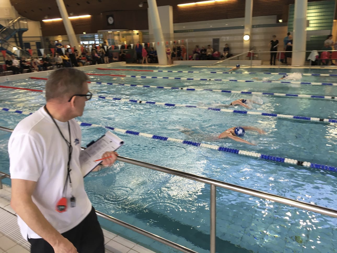 Kilpailunjohtaja Heikki Posio ratatuomarin tehtävissä seuraamassa tyttöjen 200m perhosuintia.