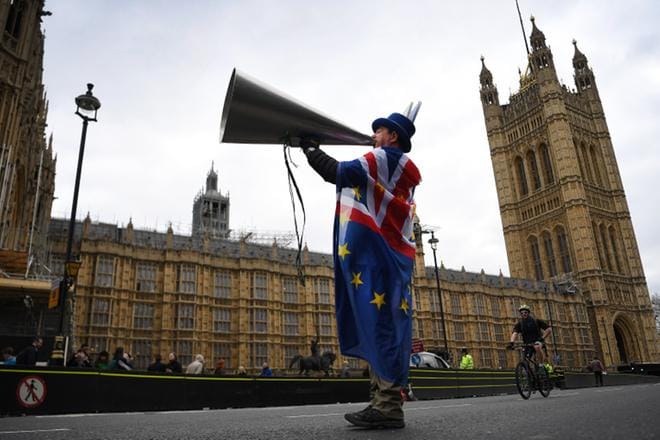 EU-mielinen mielenosoittaja parlamenttitalon edustalla Lontoon keskustassa päivystää, kun Westministerissä parlamentin alahuone äänestää suuntaa-antavasti ehdotuksista, joilla brexit-eroa yritetään kammeta pois umpikujasta. KUVA: EPA/ANDY RAIN