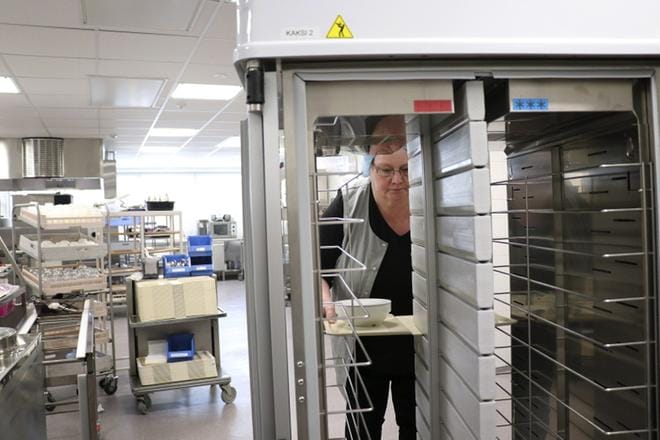 Katariina Yli-Hynnilä esittelee ruuankuljetusvaunuja, jotka uudistettiin nykyaikaiseksi remontin myötä.