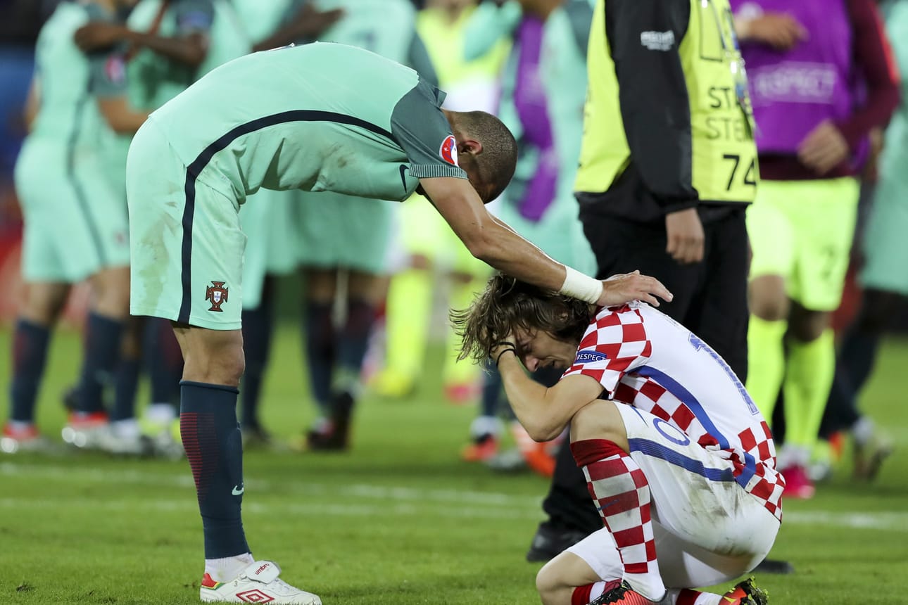 Portugalin Pepe (vas.) lohduttaa Kroatian Luka Modricia lauantaina pelatun ratkaisevan ottelun jälkeen.