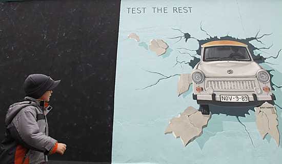 Poika katseli sunnuntaina Trabant-maalausta, joka on maalattu Berlinin muurin suurimpaan jäljelle jääneeseen osaan.