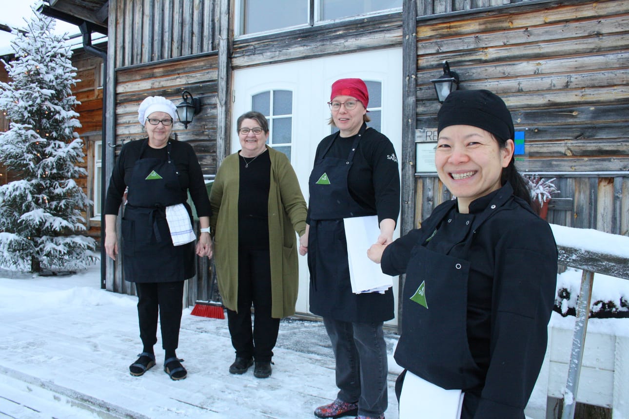 Merja Vidgren (vas.), yrittäjä Helena Karppinen, Sisko Nissinaho ja Tham Lassila Saijan Lomakeskuksen päärakennuksen portailla. Rakennuksessa on muun muassa iso ruokasali. Vanhempi osa rakennuksesta valmistui 30 vuotta sitten.