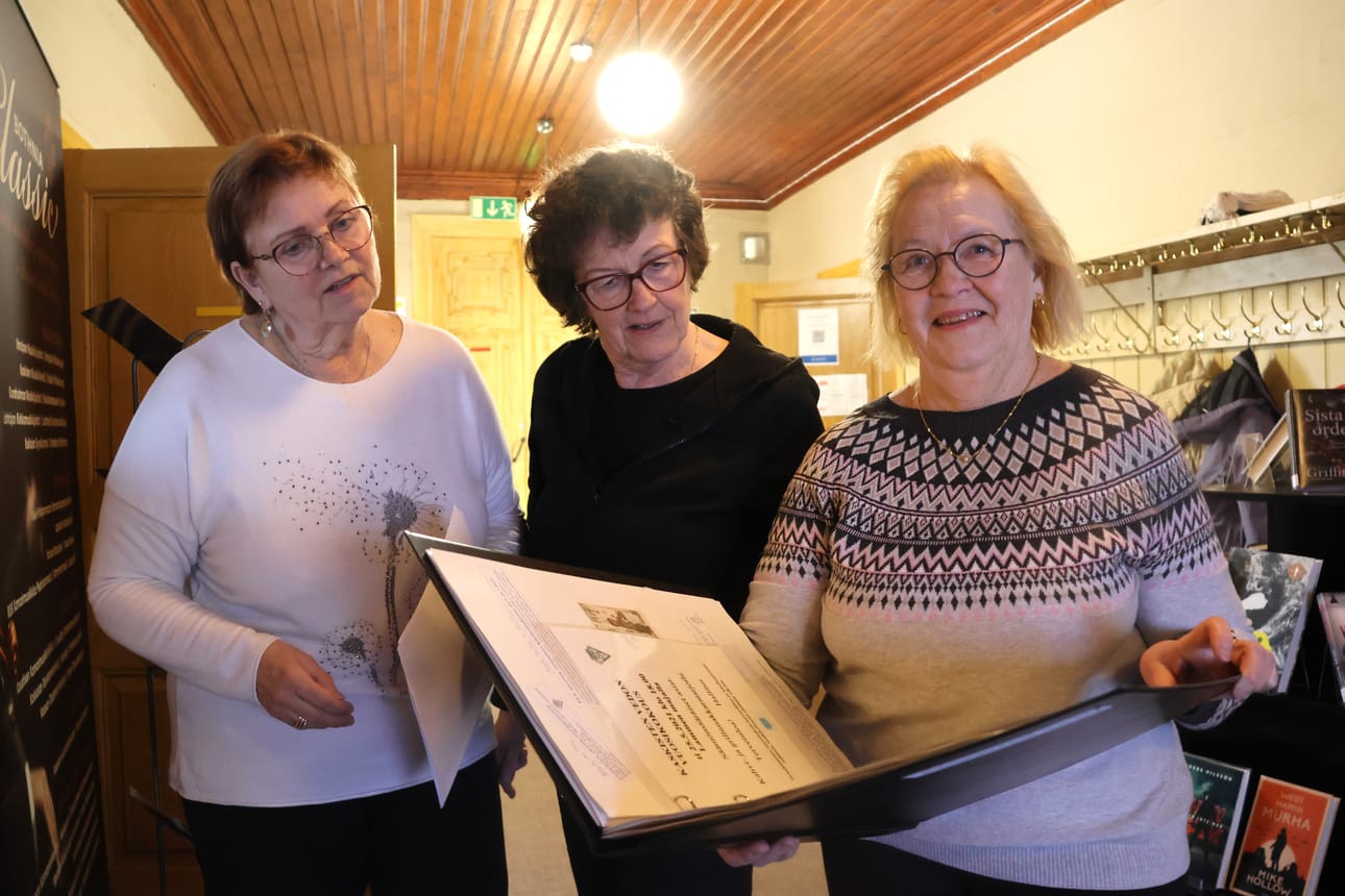 Marita Lipponen (oik.) kertoo, että Kaskisten veto tekee paljon yhteistyötä muiden kaskislaisten yhdistysten ja kaupungin kanssa. Raili Syrjälä (vas.) ja Paula Näslund tutkivat leikkelekansiota.