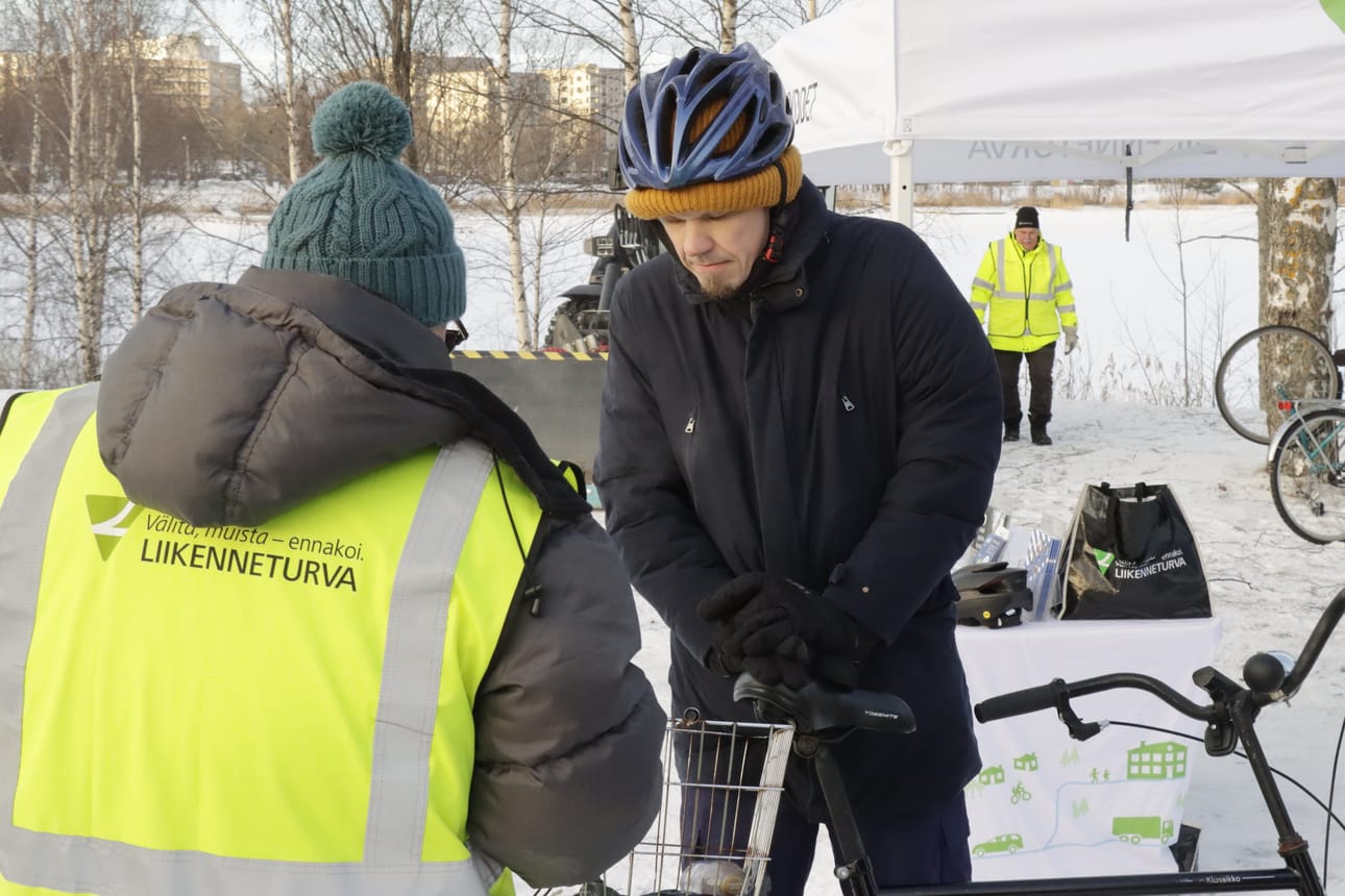 Liikenneturvan Veli Mäenpää käy läpi, mitä varusteita Mika Kivimaan pyörässä on.