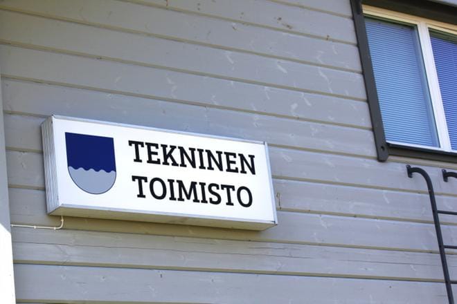 Teknisen toimiston kyltti valaisee kesäpäivää Hoiskossa.