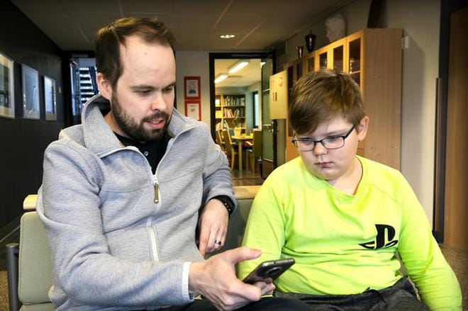 Paulaharjun koulun rehtori Heikki Peräaho ja kolmasluokkalainen Oskari Niemi tutkivat Nuorisopassi-sovellusta mielenkiinnolla.