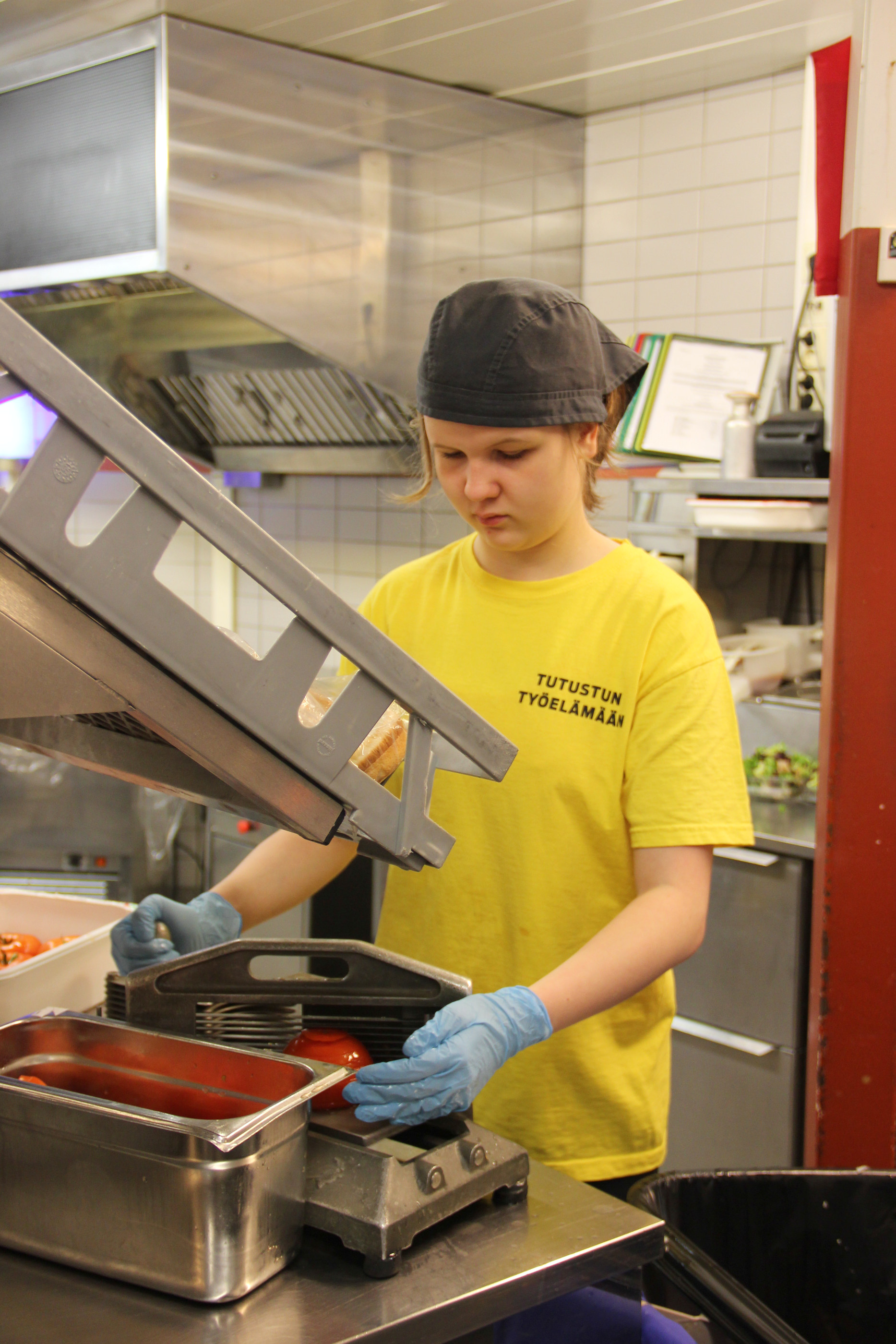Hesburgerin puolella Tuulianna Tuohimaa työstää tomaatteja.