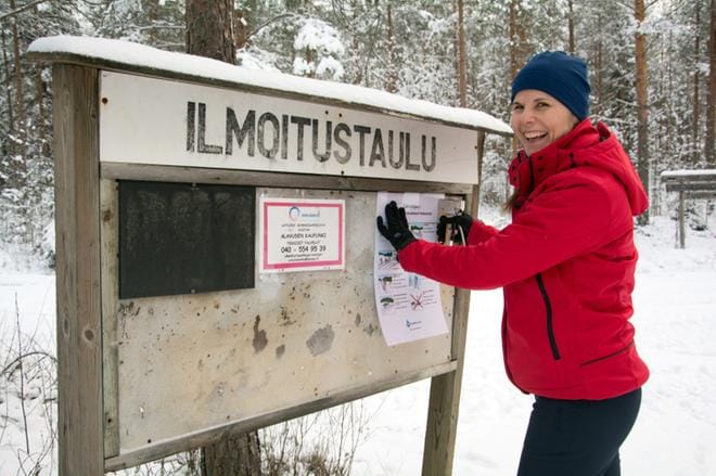 Liikunnanohjaaja Jonna Kuni-Keskinen kiinnitti Kellokorventien lähtöpaikan ilmoitustaululle Suomen ladun latuohjeet, joissa muistutetaan muun muassa väistämissäännöistä ja hyvästä latuetiketistä. KUVA: KAROLIINA SYRJÄ