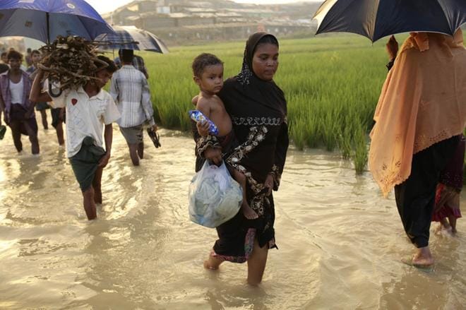 Burmasta paennut rohingya-musliminainen käveli lapsensa kanssa mutapellolla kohti Bangladeshin Cox’s Bazarin pakolaisleiriä viime tiistaina. Bangladeshin viranomaisten mukaan maahan tulee joka päivä jopa 5000 rohingyaa. KUVA: ABIR ABDULLAH/EPA