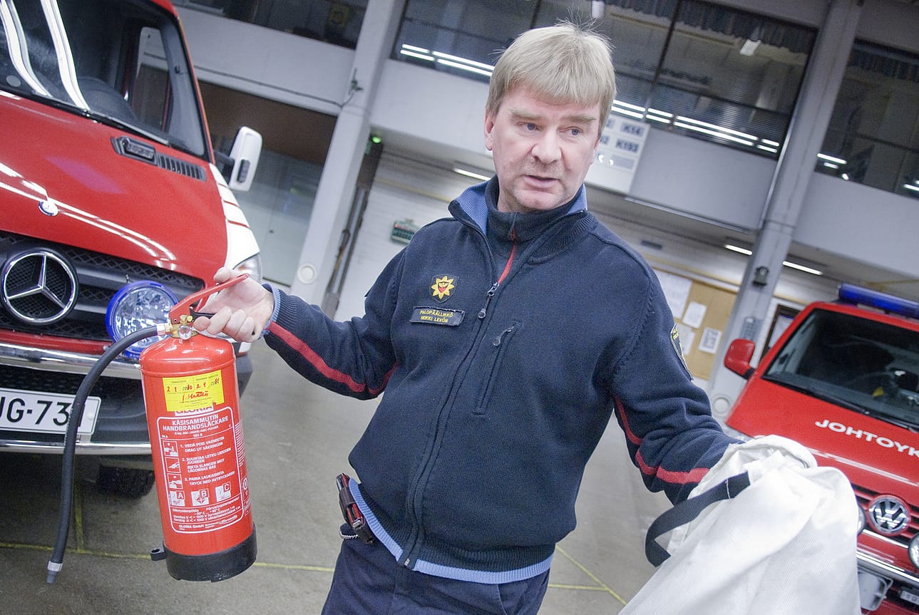 Palopäällikkö Heikki Levón esittelee alkusammutusvälineitä, jollaisia pitäisi löytyä jokaisesta kodista ja loma-asunnosta.
