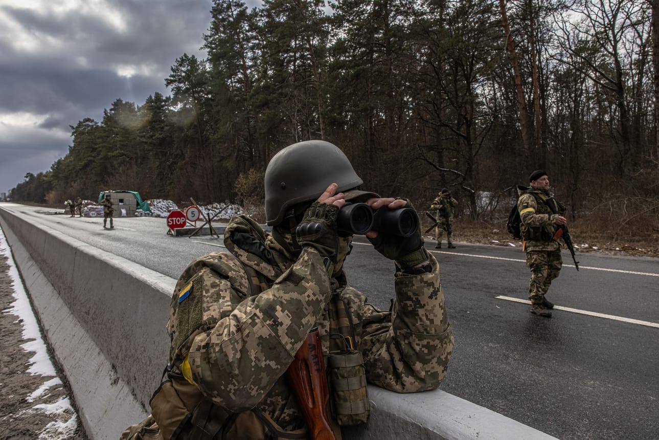 Ukrainan armeijan jäsen käyttää kiikaria tarkastuspisteessä lähellä Brovarya, Kiovan alueen itäisellä etulinjalla.