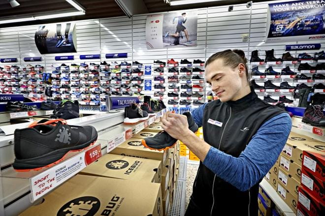 Urheiluliike Intersportin myyjät uskovat nasta- ja kitkakenkien käyvän kaupaksi Black Friday -kampanjan aikana. Myyjä Matias Mäkitöyli asettelee jalkineita järjestykseen. KUVAT: KARI LÖFHJELM