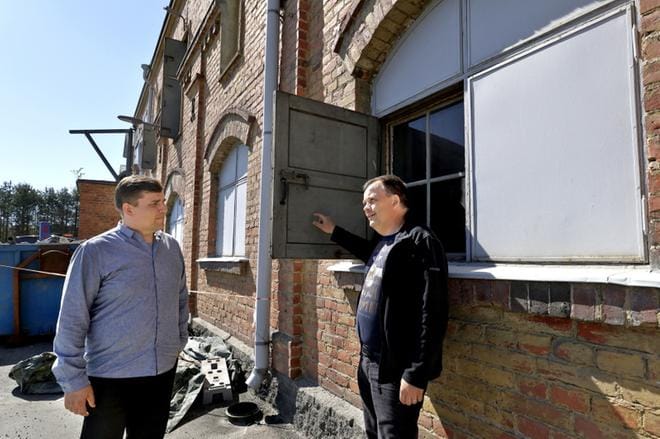 Teemu Hirvilammi ja Petri Pihlajaniemi ihastelevat sitä, kuinka kestäväksi Kalevan navetan ikkunaluukut on tehty, puhumattakaan koko rakennuksesta. Lähes sata metriä pitkä rakennus on pysynyt 120 vuotta yhtenä kappaleena ympärillä tapahtuneesta rakentamisesta huolimatta. KUVA: HEIKKI HAKANEN