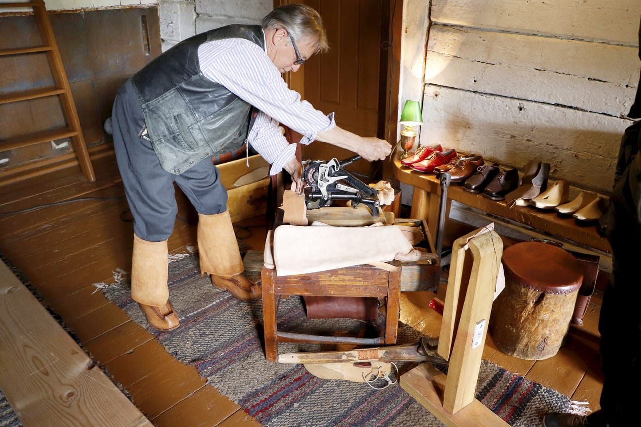 Monitoimimies, suutari Timo Stenius esitteli tuotantoaan ja työvälineitään. Käsissä kuvassa "suutarin kissa".