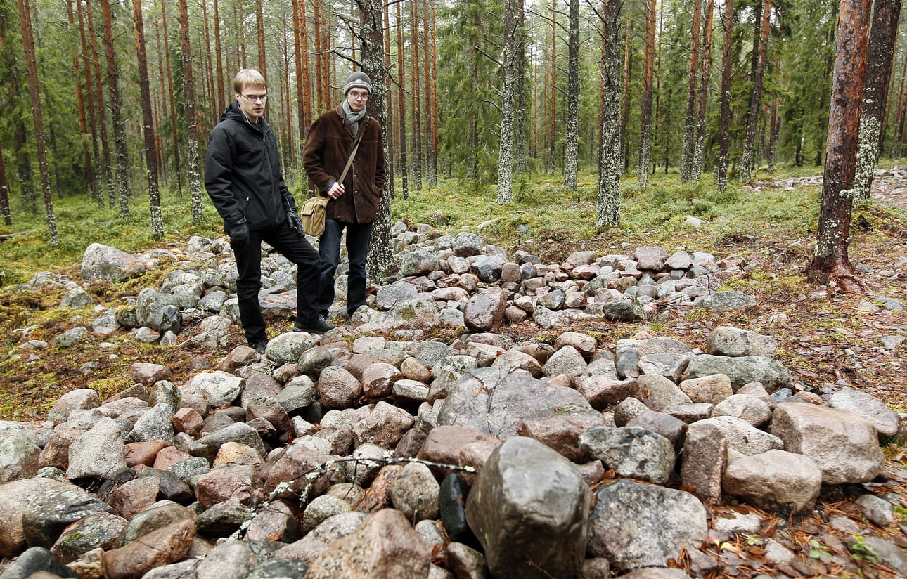 Arkeologit Jari-Matti Kuusela (vas.) ja Ville Hakamäki rautakautisen kalmiston keskellä Oulun Hiirosessa. Röykkiöhaudoista moniin on kajottu luvatta. Arkeologiset kaivaukset alueella tehtiin viime syksynä.