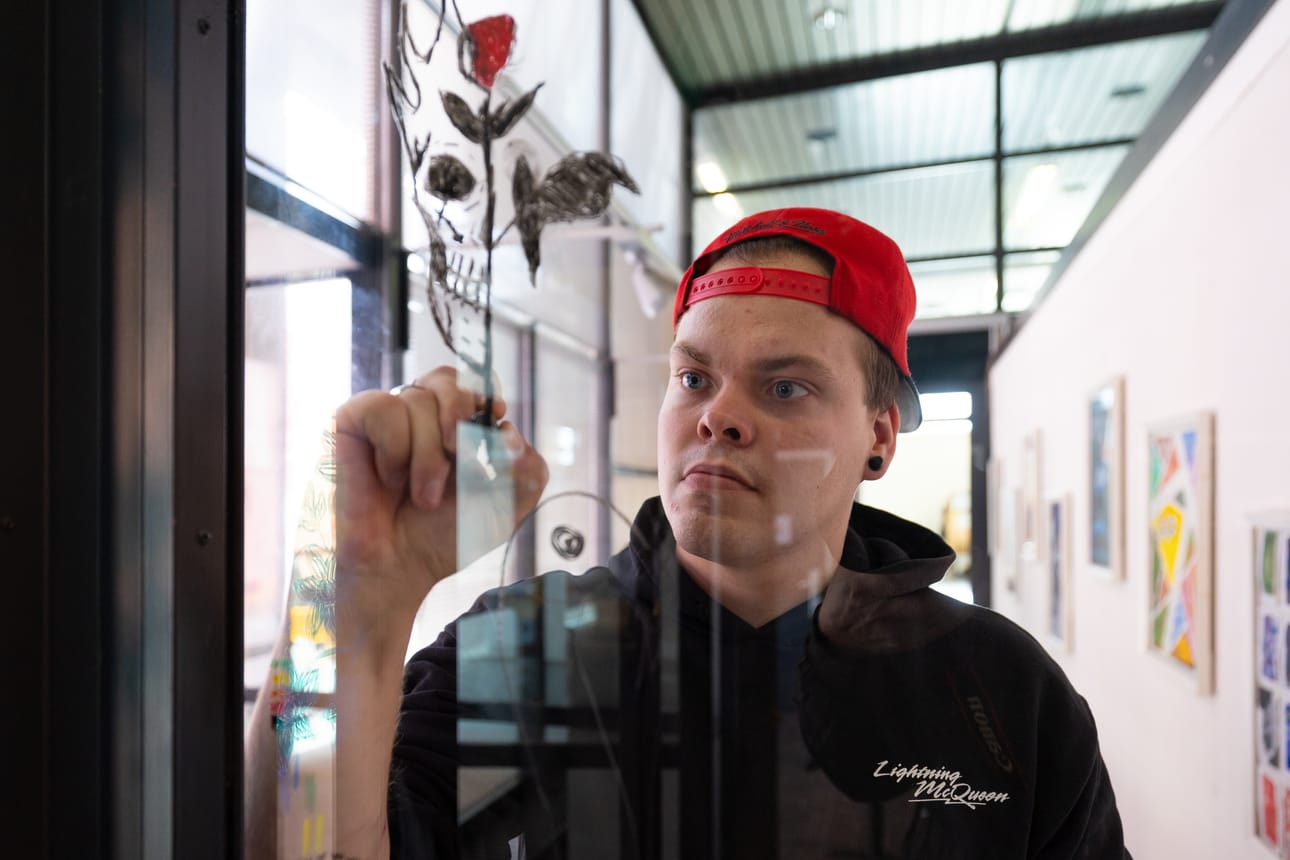 Matias Lamminmäki tykästyi kohtaamispaikka Jojoon ja piirsi taideikkunaan saman tatuoinnin, joka löytyy hänen käsivarrestaan kolarista selviytymisen muistona.