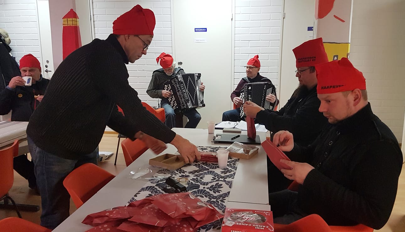 Rotaritontut ahkeroivat paketteja erityislasten pikkujouluun kauniin haitarimusiikin soidessa taustalla.