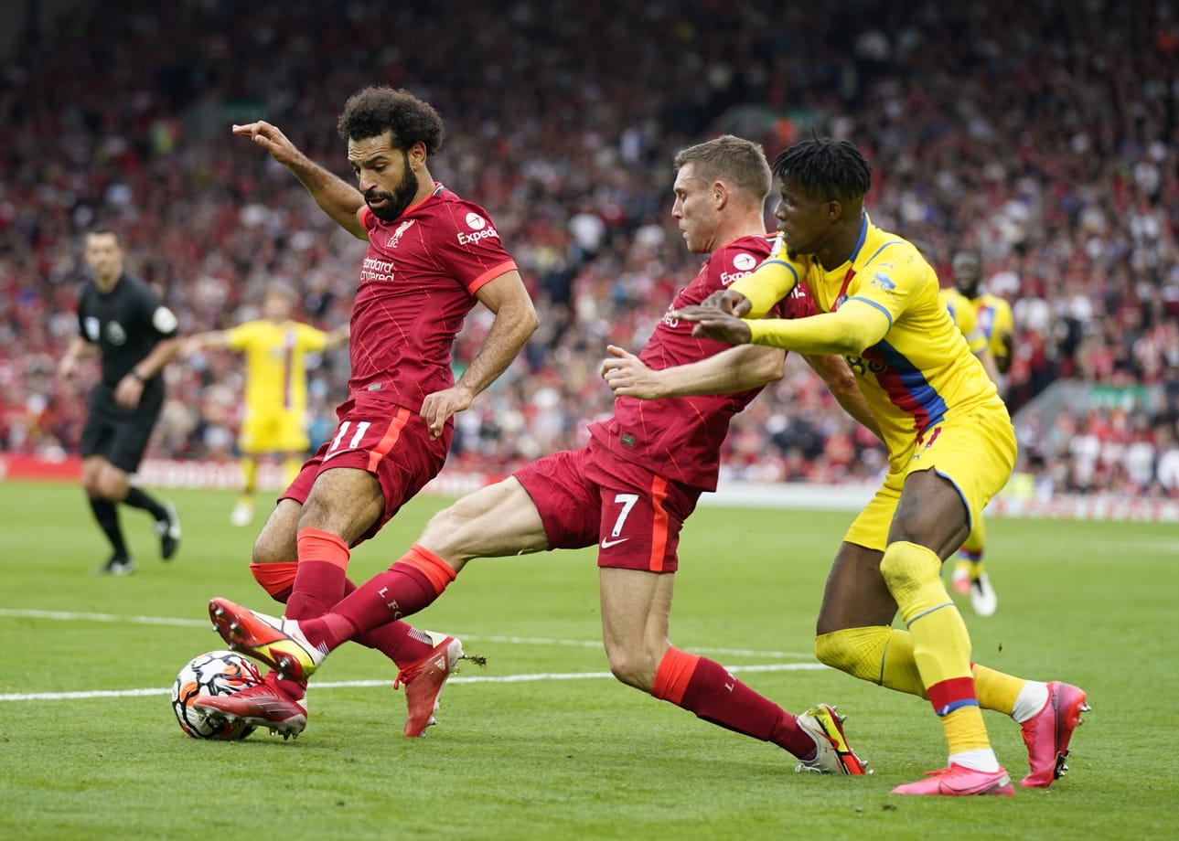 Crystal Palacen Wilfried Zaha (oik.) yrittää taistella Liverpoolin Mohamed Salahin (vas.) ja James Milnerin kanssa.