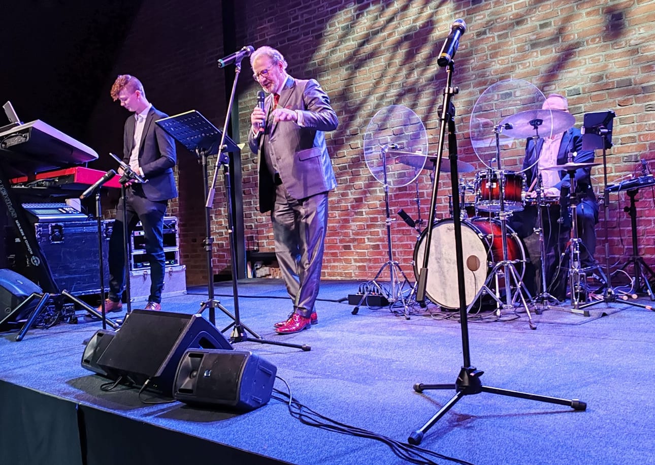 Kivikasvojen jäsen Henrik Lamberg juontaa Elämäni tango -konsertin. Muusikkoina toimivat Rami Loukola (vas.) ja Timo Saarimäki.