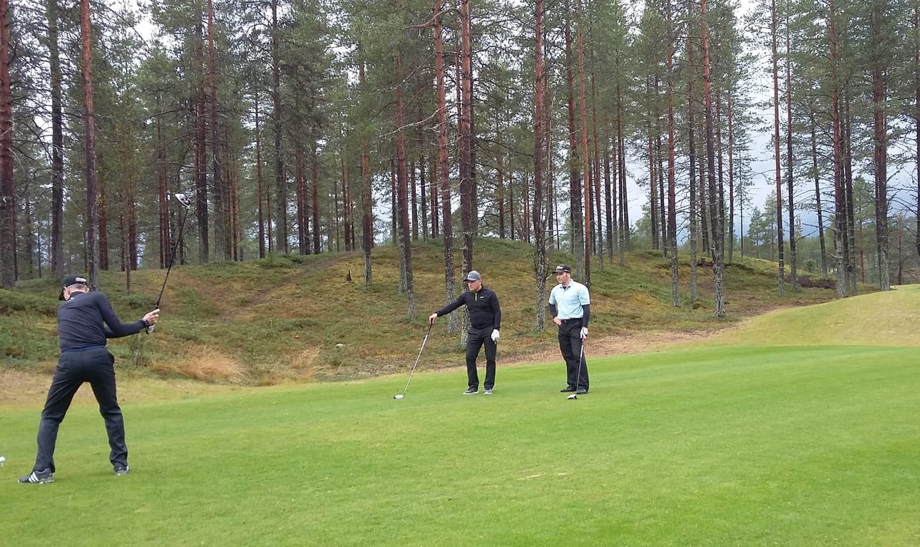 Hyvin sijoittuneet Lasse Liikanen ja Jarkko Tammi seuraavat kilpakumppanin avauslyöntiä väylällä 12. Takana olevalta mäeltä näkyy osia kentän 11 eri väylästä.