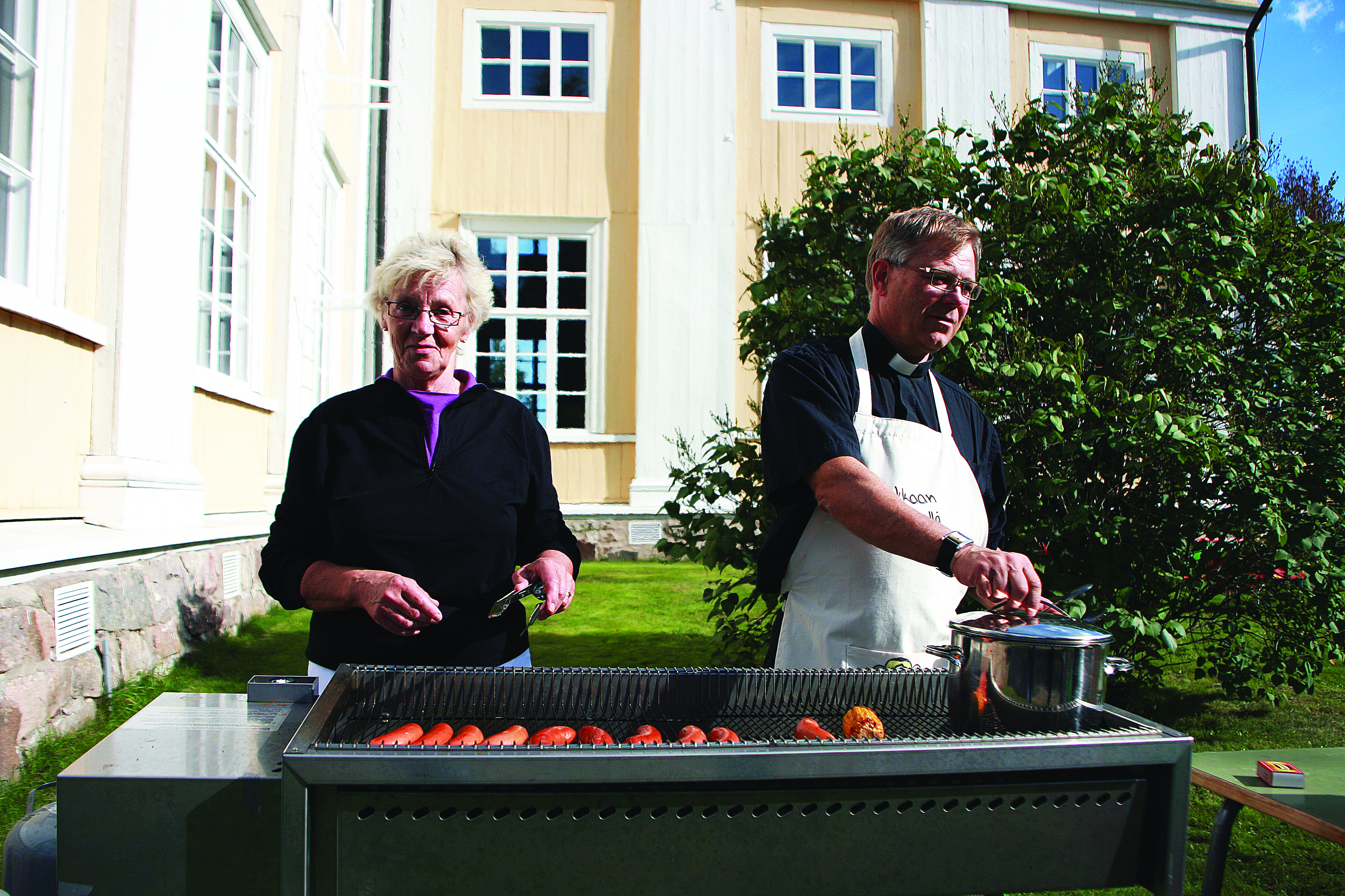 Seurakunnan emäntä Sirkka Puusaari  ja kirkkoherra Ilkka Tornberg paistoivat halukkaille makkaraa viime kerralla. Tänäkin vuonna Tornberg nähdään grillin ääressä.