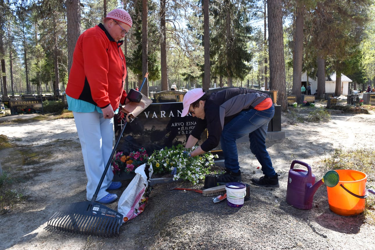 Aini Varanka (vas.) istutti orvokit ja lumihiutaleen keskiviikkona appiukkonsa haudalle. Apuna oli serkku Rauni Karjalainen.
