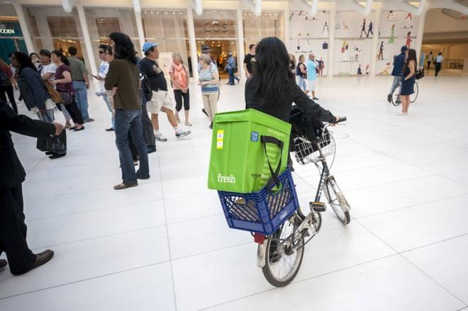 Vihreä muovinen kantolaukku on Amazon Freshin tuntomerkki. New Yorkissa nainen oli ottanut ruokakaupan tuoretavarakassin mukaan kaupunkireissulle toimien samalla verkkokaupan mainoksena. KUVA:
