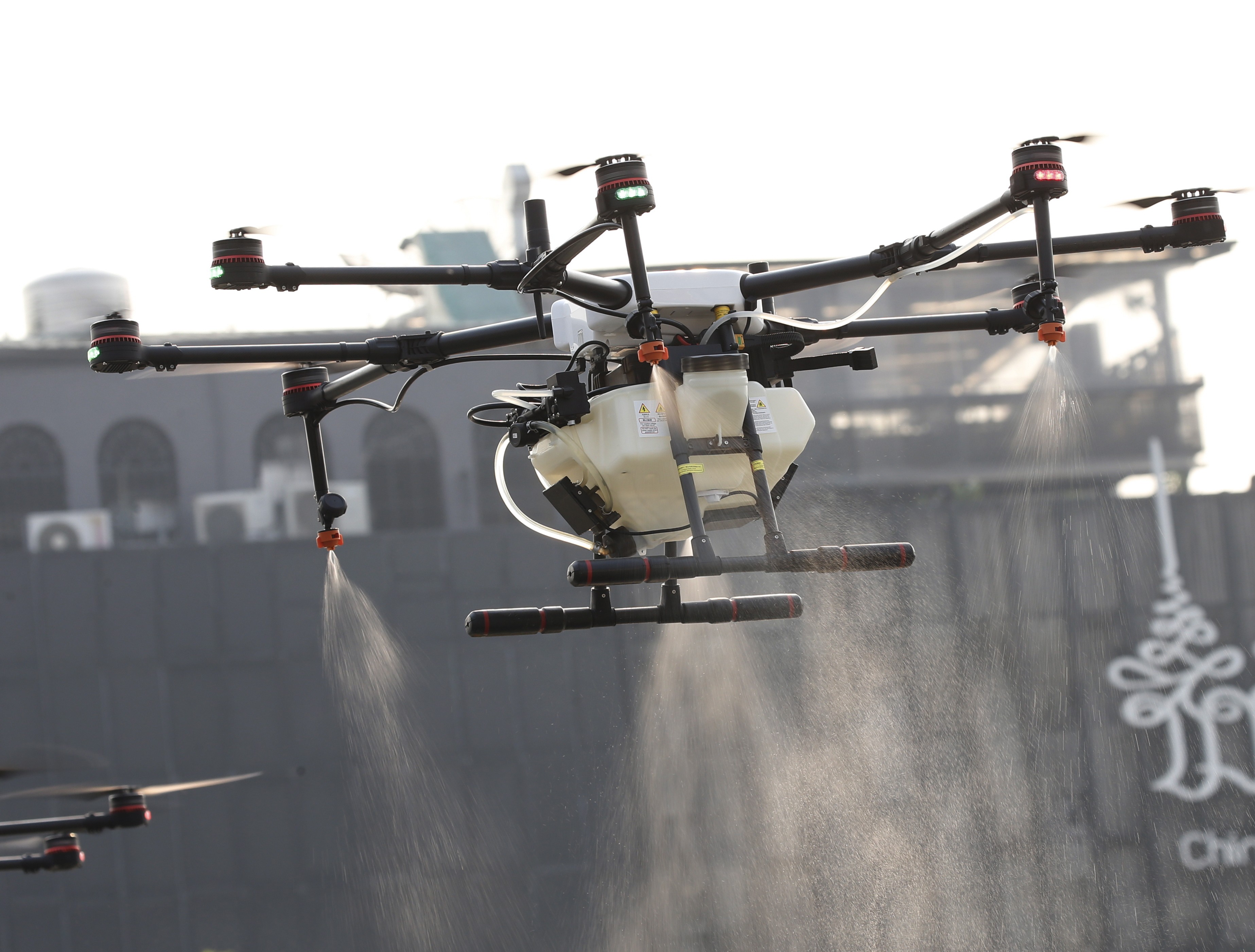 Maatalouskäyttöön suunniteltu drone suihkuttamassa vettä ilmaan Bangkokissa torstaina.