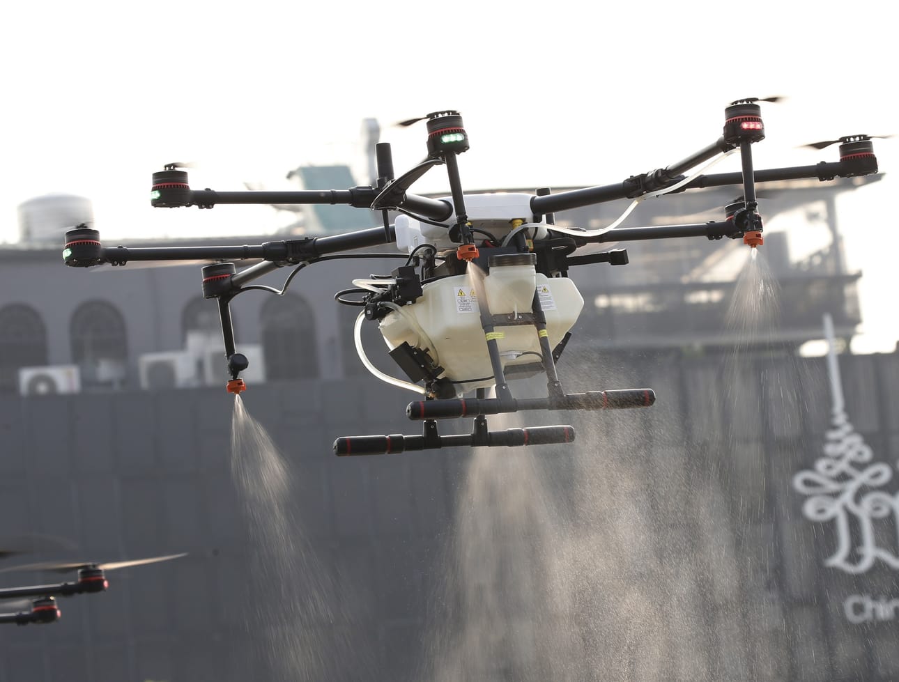 Maatalouskäyttöön suunniteltu drone suihkuttamassa vettä ilmaan Bangkokissa torstaina.