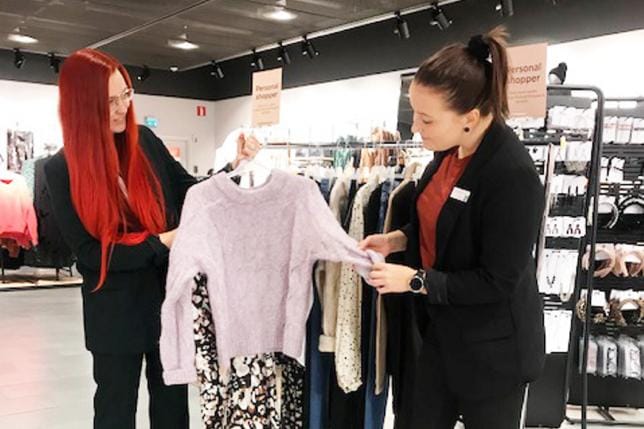 Lindexin personal shopper Ann-Mari Westerlund (vas.) ja myymäläpäällikkö Anni Svanfors näyttävät, miten neuleen kanssa voi yhdistää esimerkiksi kuviollisen hameen. Kuva: Henna Kontola