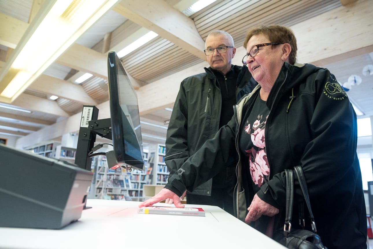 Vuoden Lainaaja -palkinnon Kuusamossa saaneet Airi Matikainen ja Martti Lehtinen tutustuivat torstaina uuden lainausautomaatin toimintaan.