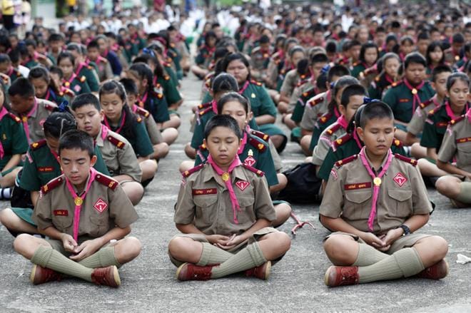 Oppilaat meditoivat ja lähettävät henkisen tukensa pelastusoperaatiolla Maesaiprasitsartin koulussa Chiang Rain provinssissa Thaimaassa 6. heinäkuuta 2018. KUVA: EPA/RUNGROJ YONGRIT