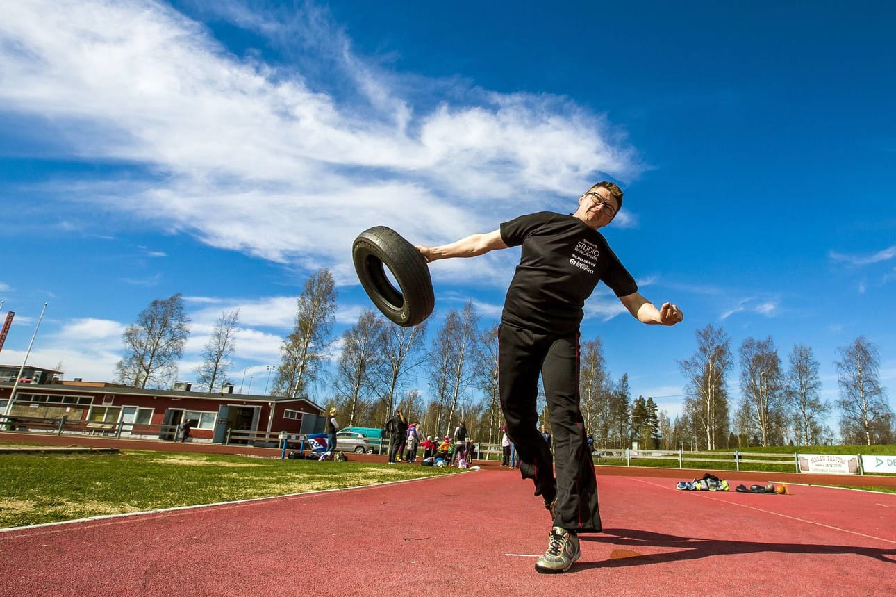Juha Korpi näyttää mallin autonrenkaanheitosta. Perinneurheilukisoissa heitetään myös saapasta, linkopalloa ja voimakiekkoa.