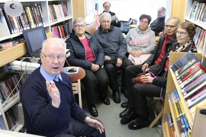 Juhani Aho (vasemmalla) tarinoi elokuvista, soitti elokuvamusiikkia ja näytti elokuva-aiheisia kuvia. Kiinnostuneina kuulijoina olivat paikalla Lea (oikealla) ja Pentti Ahokas, Eija Kanervisto, Lauri ja Terttu Lähde sekä takana Raimo Kanervisto (oikealla) ja kirjastoautovirkailija Juhani Akonniemi. KUVAT: REIJO HEIKKILÄ
