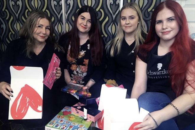 Suvi Pirttiperä (vas.) ja vierällään Sonja Pränny paketoivat jouluisia lahjoja tulevaa tapahtumaa varten. Mukana auttavat myös opiskelijat Julia Myllyaho ja Jonna Nurkkala (oik.). Kuva: Suvi Pirttiperä