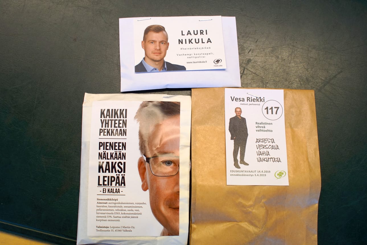 Lauri Nikulan vaalipussista löytyy rairuohon siemeniä, Vesa Riekin pussista käpy metsänviljelyohjeineen. Pekka Aittakumpu luottaa leipään.