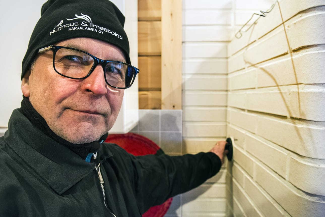 Esa Karjalainen näyttää, että sytytyspelti suljetaan, kun tulisija on saatu syttymään.