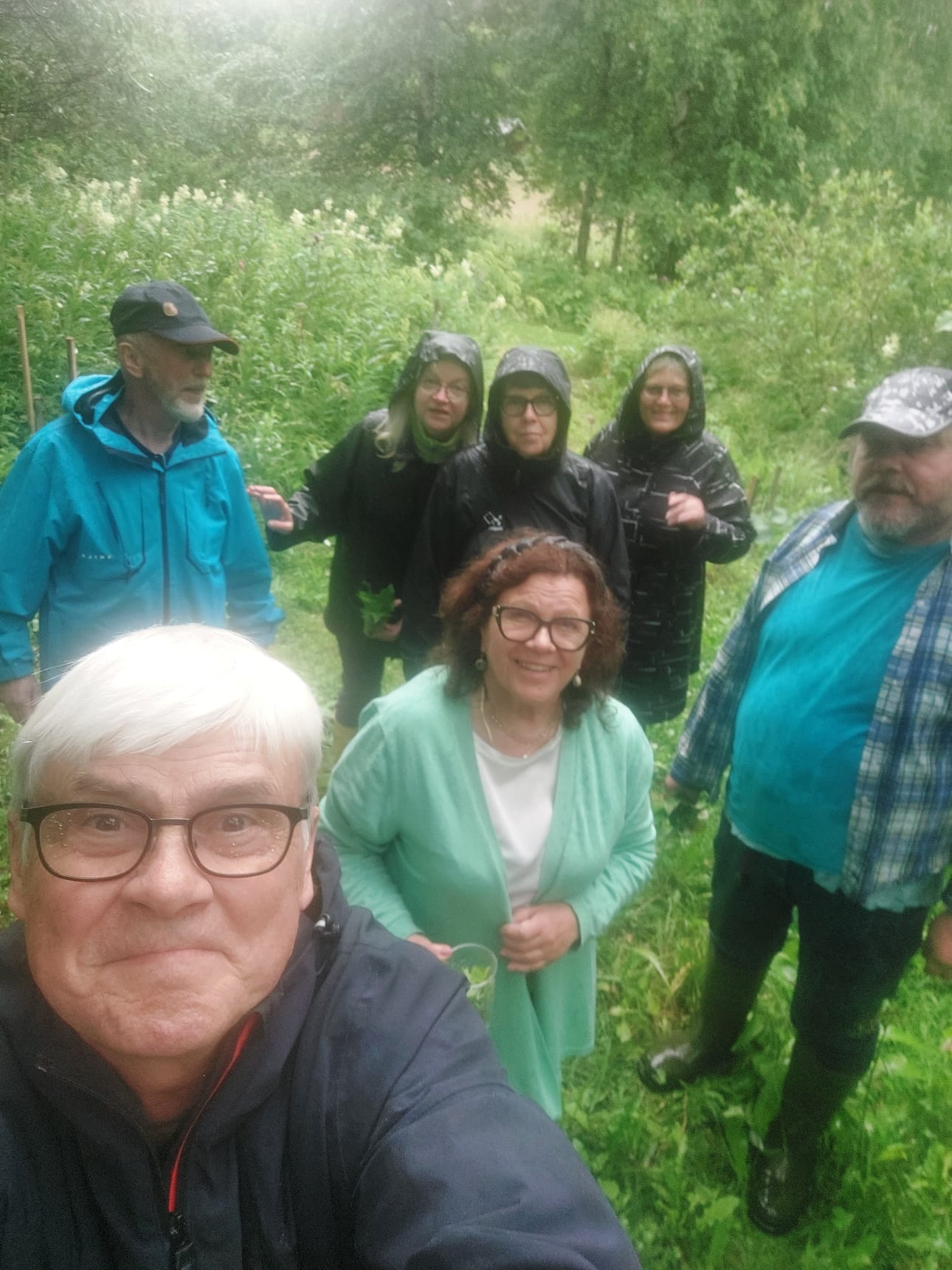 Osa ryhmästä selfiekuvassa pikku sateessa. Paavo Ahonen oikealla
