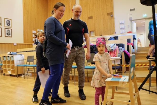 Emitin leimaaminen oli niin haluttua puuhaa, että siitä tuli Hydénin jälkikasvulla ankara kina. Tässä leimausvuoroon pääsi 4-vuotias Teea. Jere odottelee vuoroaan Henna-äidin selän takana. Janne Hakanen tarkkailee tilannetta. KUVAT: JAANA-STIINA ALA-KORPI