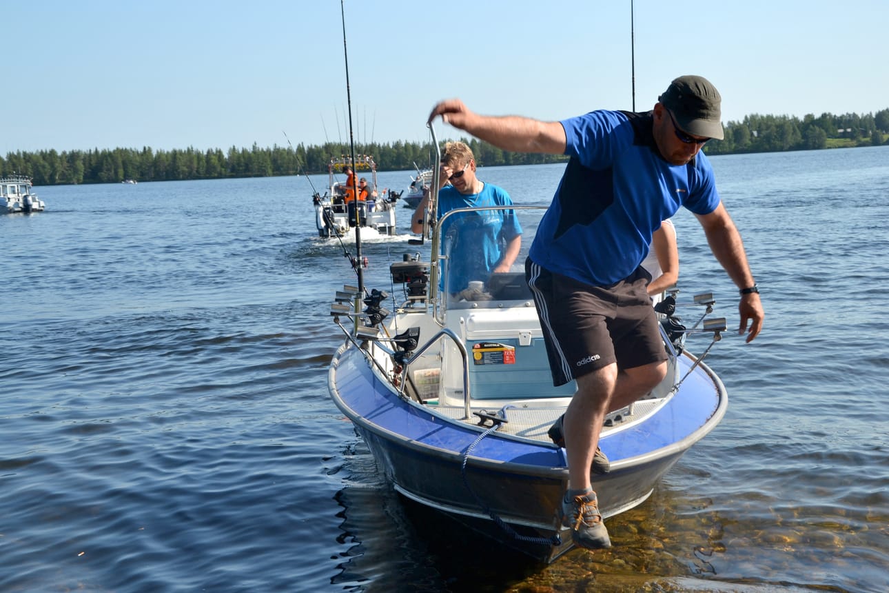 Mika Reijonen loikkasi vielä rannalle hakemaan viimeisiä tarvikkeita hieman ennen Muojärven lohenuistelun starttia. Kippari Jussi Väänäsen venekuntaan kuului myös Päivi Kiiskinen.