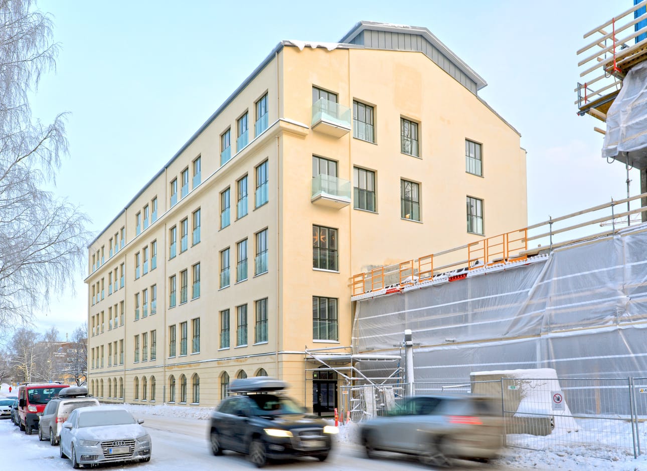 Historiallinen pelkistetty tehdasarkkitehtuuri on säilynyt hienosti uudistuksessa. Arvioitavan ylimmän kerroksen asunnon parveke näkyy kuvassa etualalla.