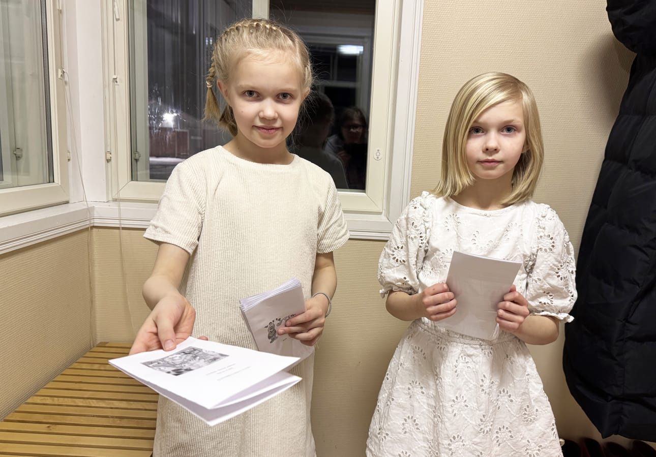 Seelia Yrjänä ja Vanessa Yrjänä toivottivat kirjan julkaisuillan kutsuvieraat tervetulleiksi. Tilaisuutta varten oli tehty ohjelmalehtinen ja tulostettu myös yhteislaulun sanat.