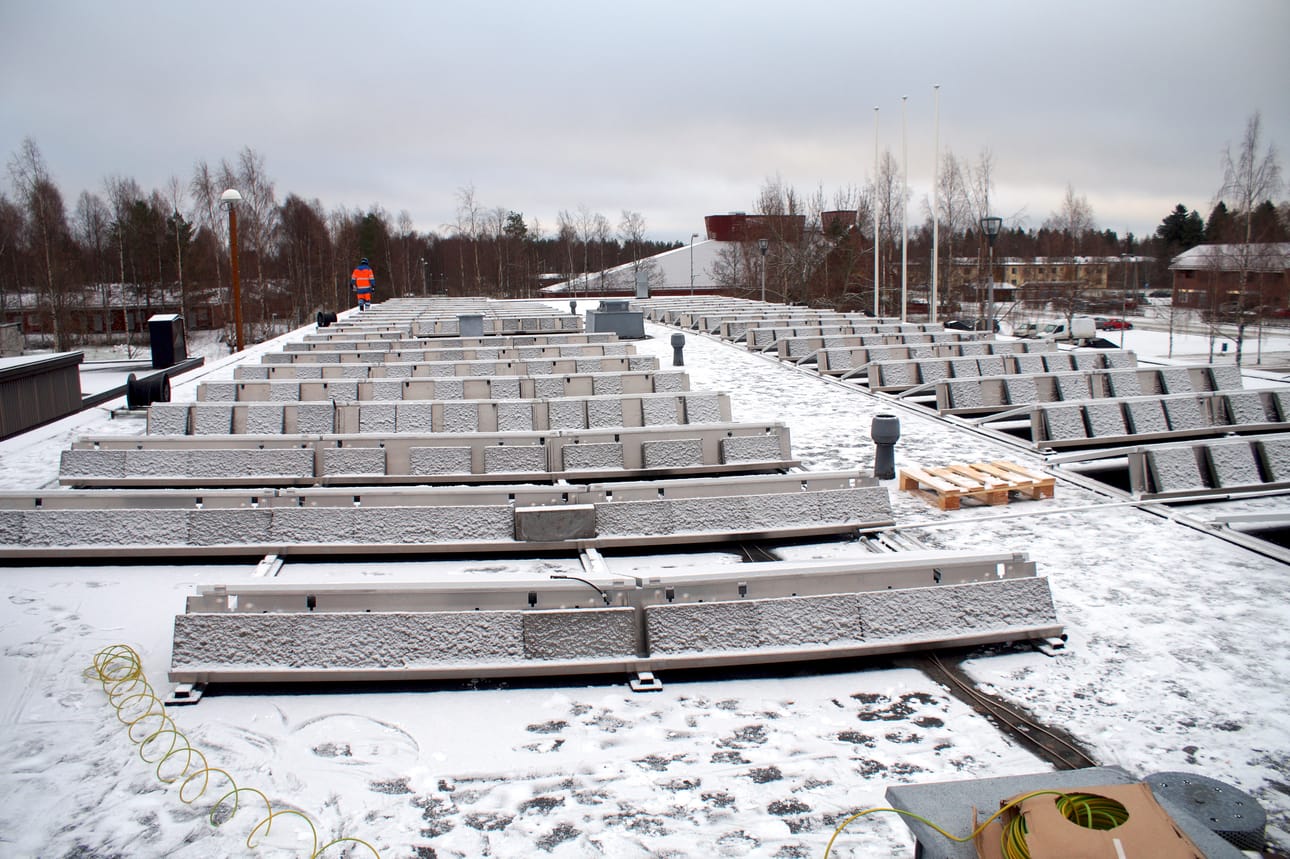 Aurinkovoimalan paneelit pysyvät kaupungintalon katolla betonisten painojen voimin.