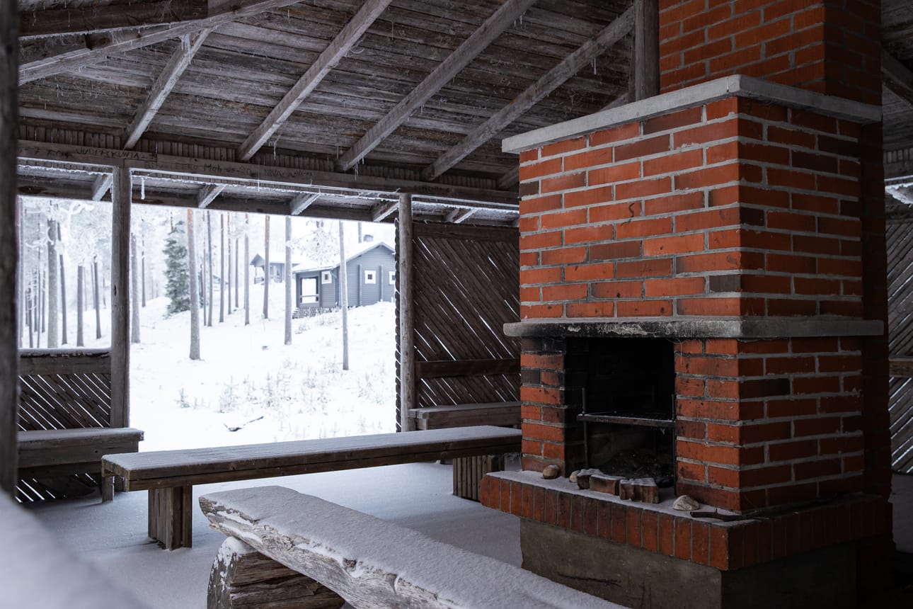 Rinteessä sijaitsevien mökkien lähellä on kierrätyspiste ja grillikatos.