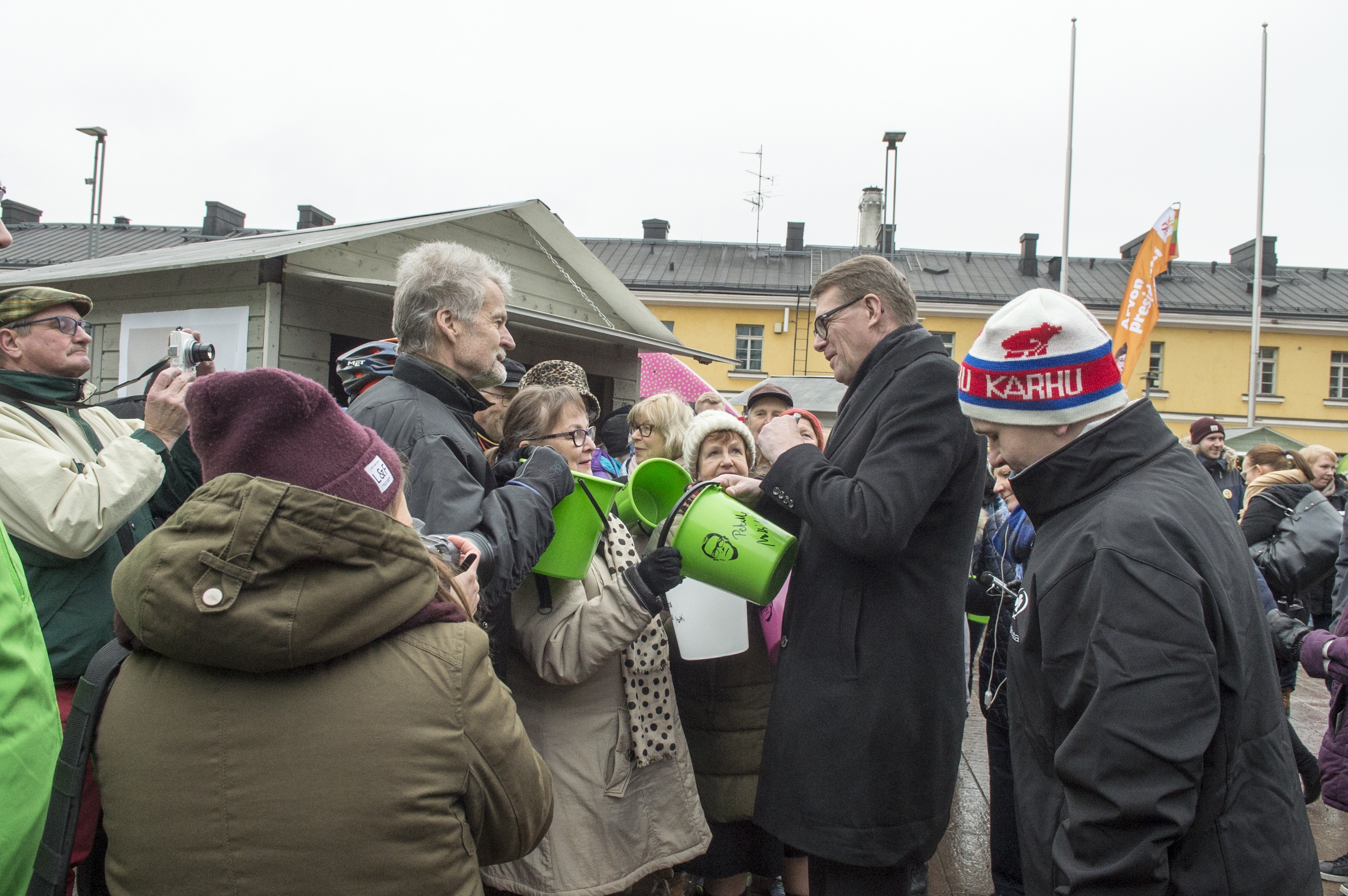 Matti Vanhasen (kesk.) jakamat ilmaiset ämpärit keräsivät väkeä Helsingin Narinkkatorille lauantaiaamupäivällä.
