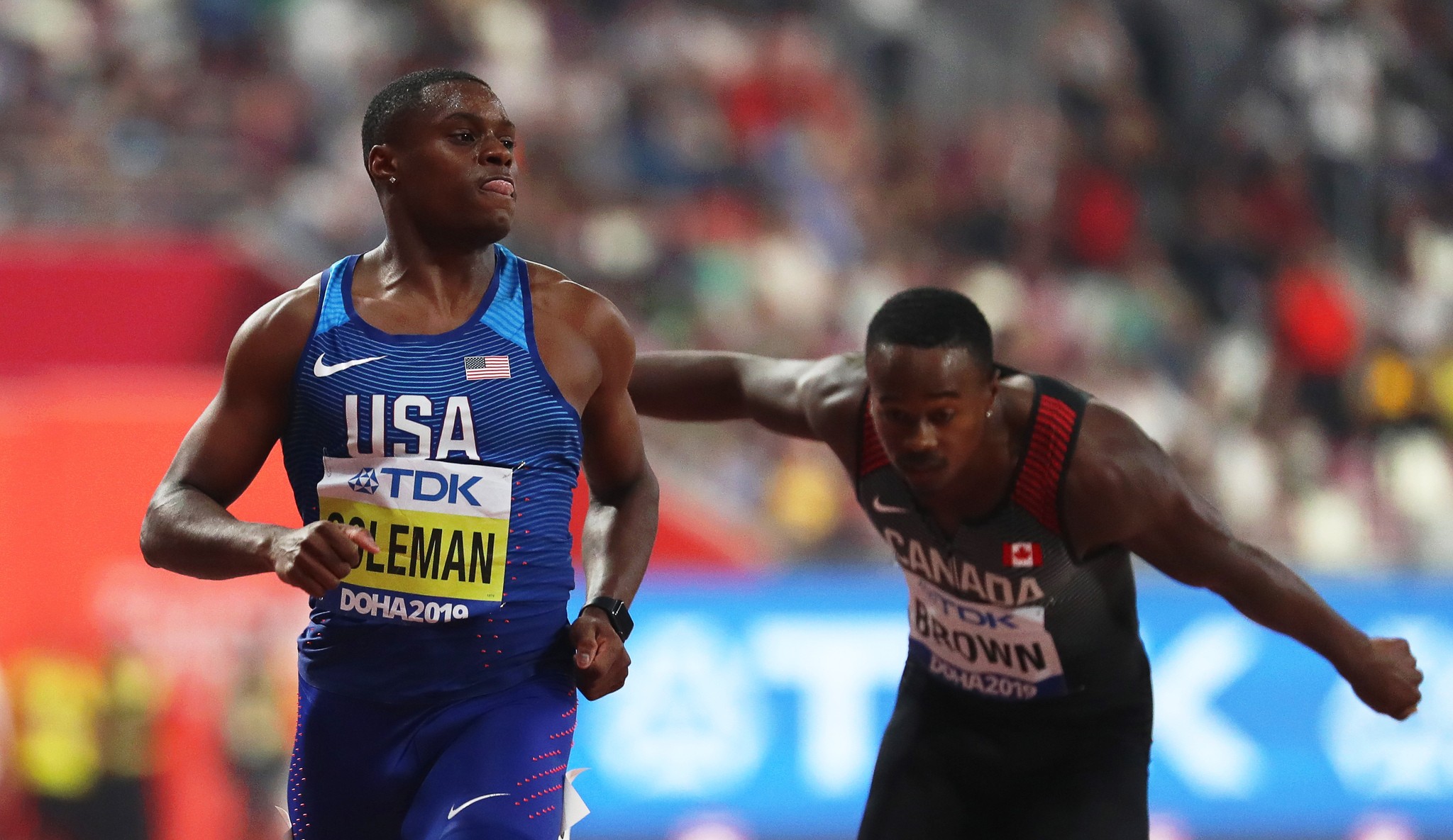 Christian Coleman (vas.) voitti satasen MM-kultaa. Taustalla venyttävä Kanadan Aaron Brown jäi finaalin viimeiseksi. Kuva semifinaalista.